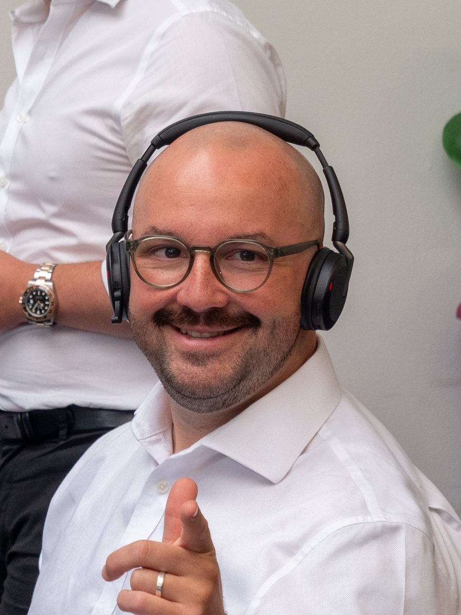Alex W of Aspire Estates at his desk, pointing to camera