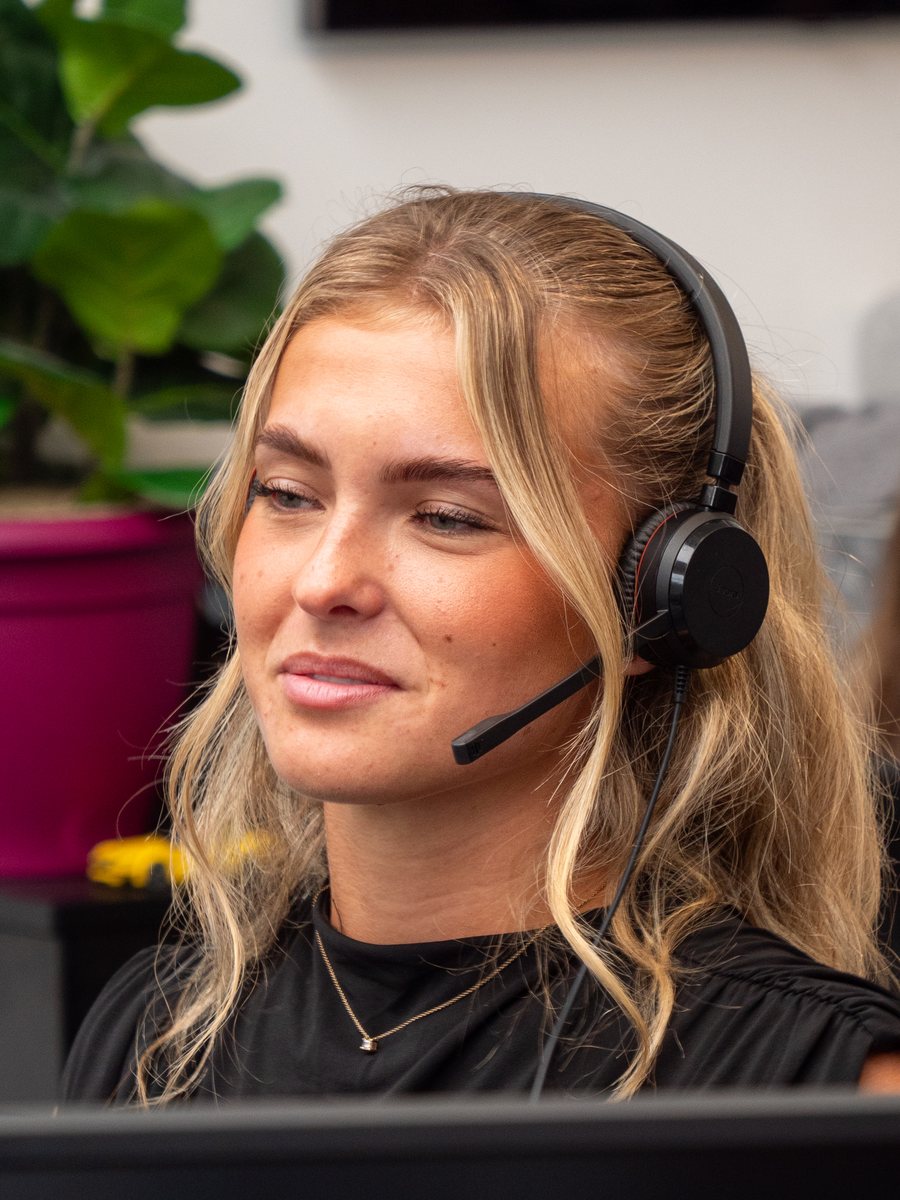 Libby of Aspire Estates at her desk, wearing a headset