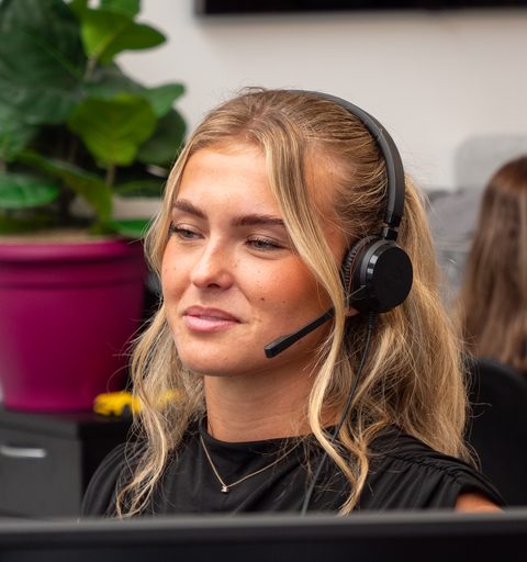 Libby of Aspire Estates at her desk, wearing a headset